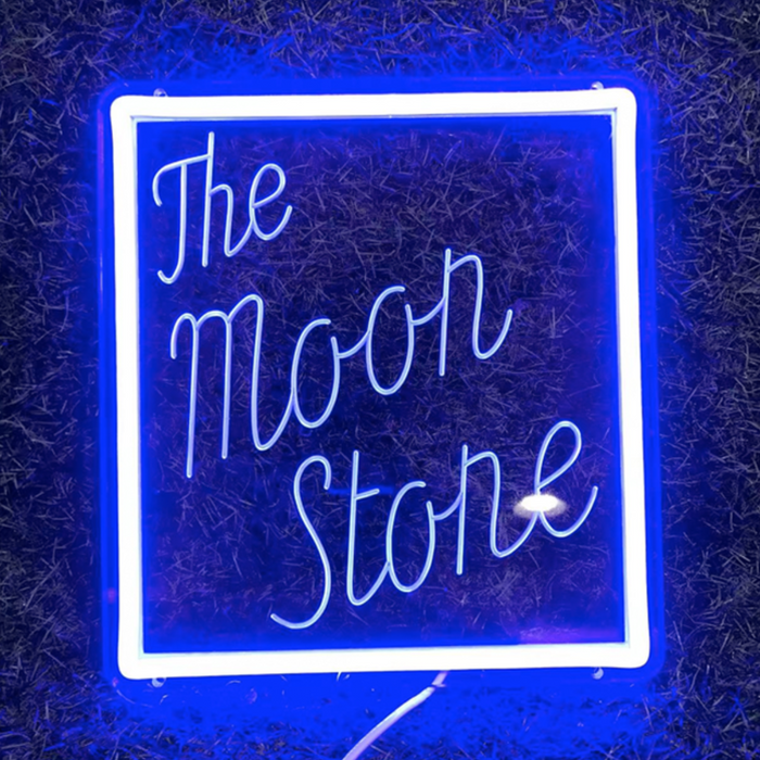A neon sign that reads 'The Moon Stone' in a square frame with a blue background.